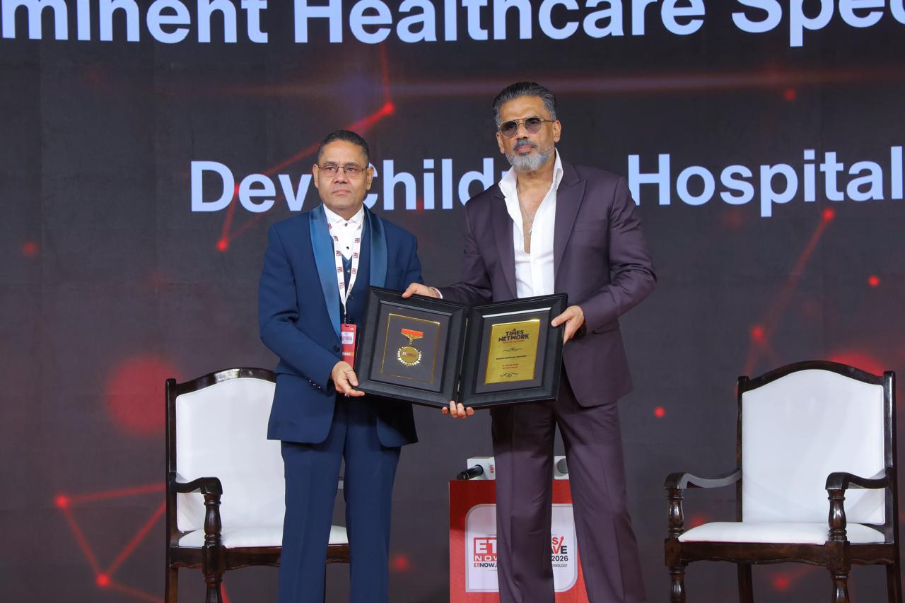 Award-winning pediatrician in Vadodara Dr. Anurag Singh holding national healthcare award on stage