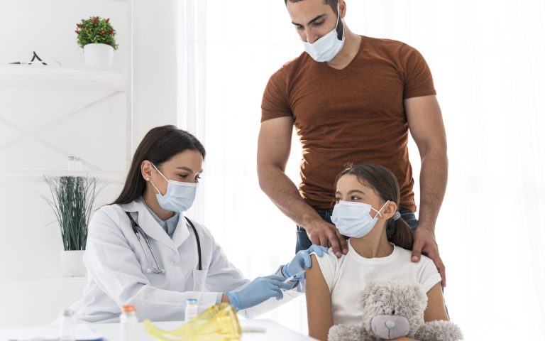 girl-holding-her-toy-while-being-vaccinated